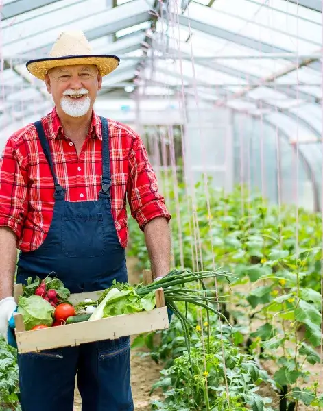 Smiling farming scientist in a safety uniform in greenhouse